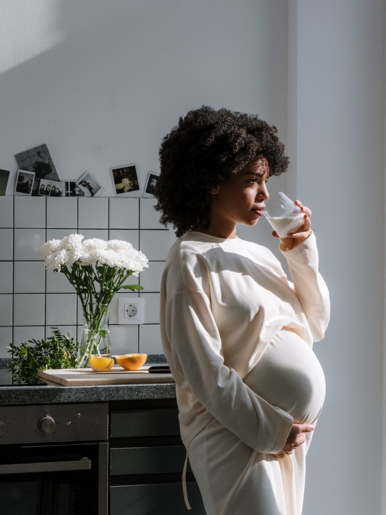 Expecting mother holding her belly and thinking about a comment made regarding her belly size.