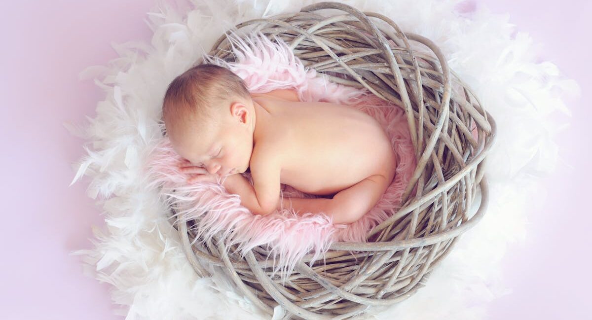 Baby curled up in a basket.