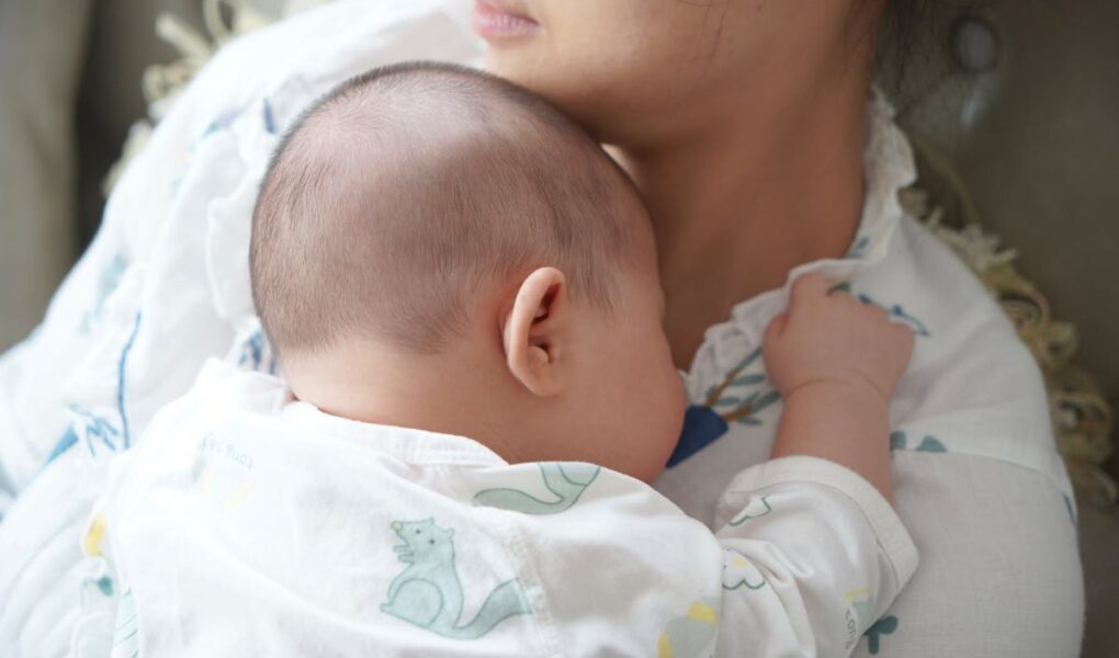 Mother holding baby on her chest. Postpartum time.