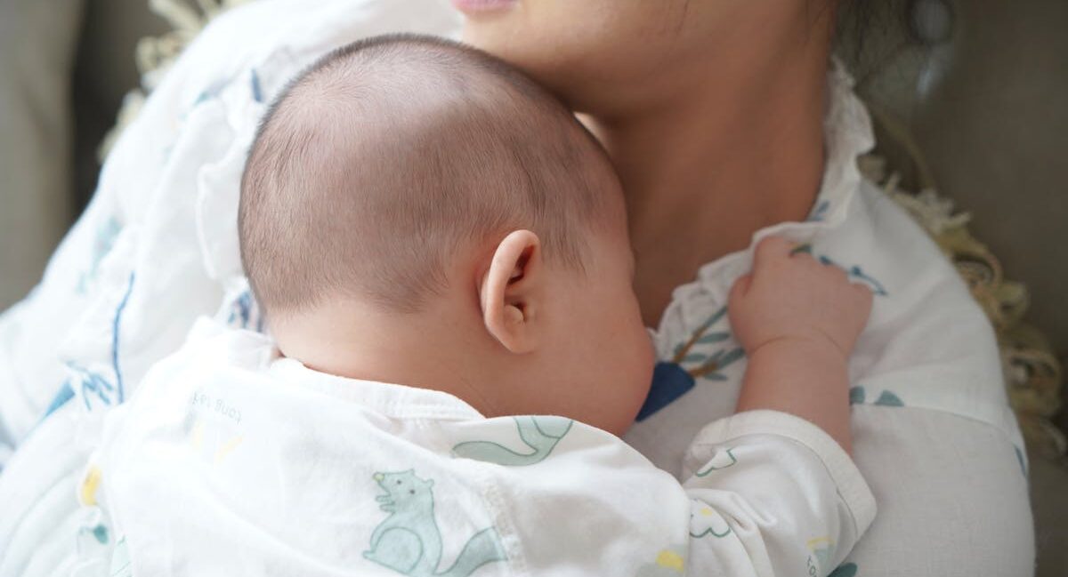 Mother holding baby on her chest. Postpartum time.