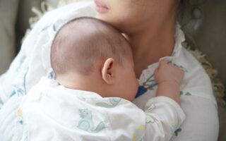 Mother holding baby on her chest. Postpartum time.