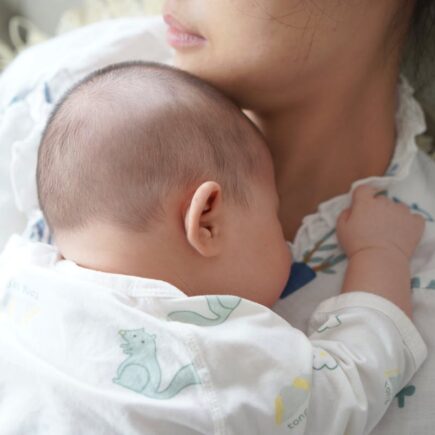 Mother holding baby on her chest. Postpartum time.