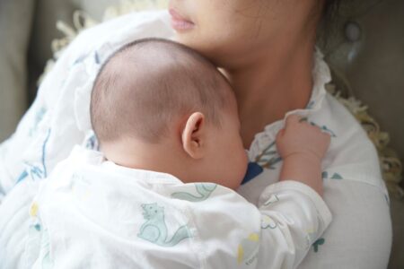 Mother holding baby on her chest. Postpartum time.