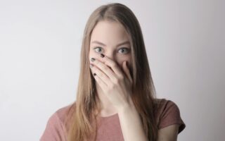 Woman covering her mouth with one hand