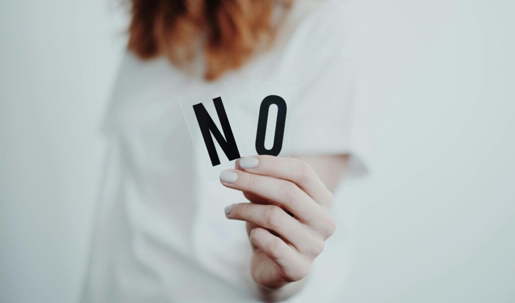 Woman holding the letters N and O to make the word no.
