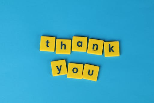 Yellow letter tiles spelling thank you.