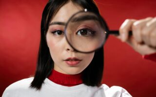 Woman looking through a magnifying glass.