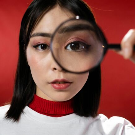 Woman looking through a magnifying glass.