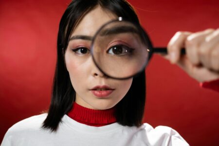 Woman looking through a magnifying glass.