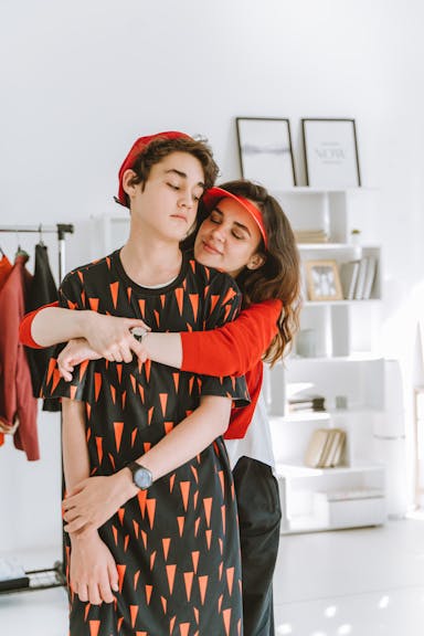 Mom hugging teens on from behind.