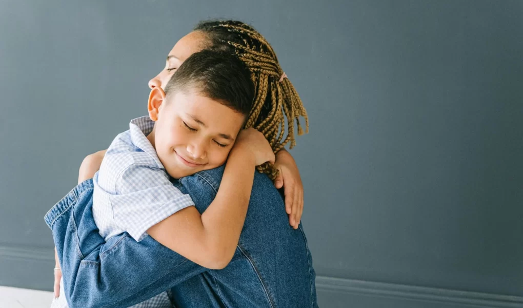 Mother and son hugging.