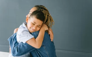 Mother and son hugging.