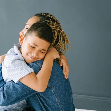 Mother and son hugging.